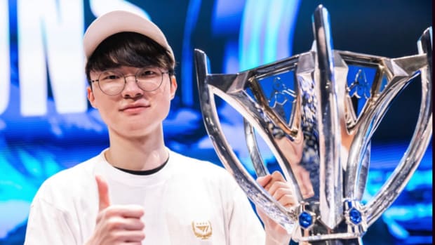 Faker poses holding the Summoners Cup